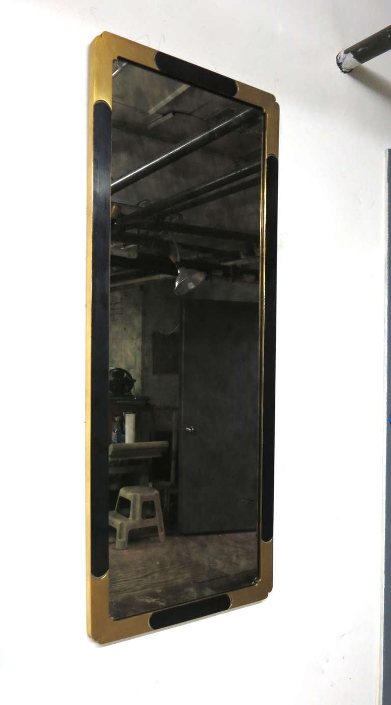 Mirror in with gold leaf and black lacquer border and a antiqued glass mirror has rounded detail at each corner.