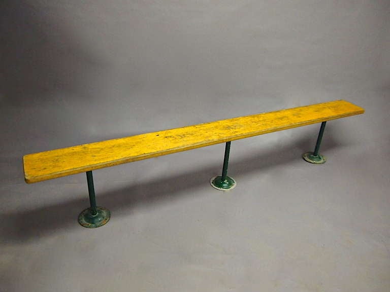 Bench with a nine foot long wooden seat that is supported by three green enameled metal legs that mount into the ground. More Available in 3 sizes