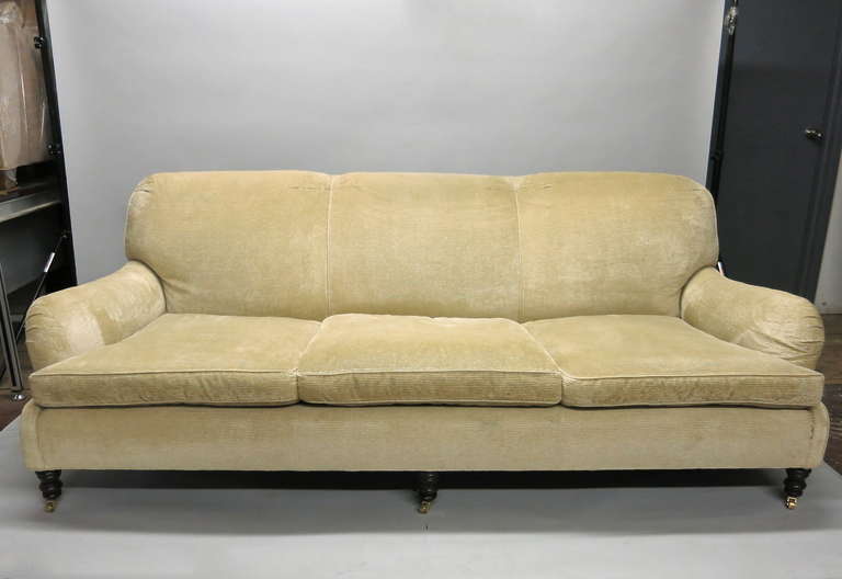 Pair of matching sofa's in off white corduroy each supported by six carved wood legs on brass casters. Purchased in the 90's at RL and hardly used have been wrapped in storage. Fabric is in great condition