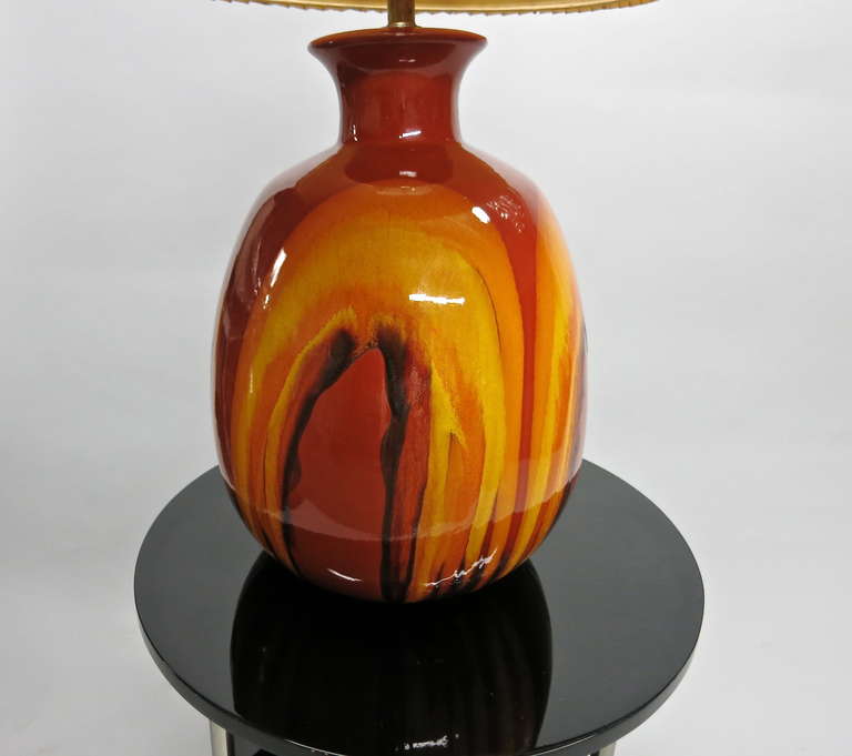 Pair of ceramic table lamps large-scale in mixed colors of orange some yellow and a bit of black. The shades are original to the lamps and have a pinch pleat detail with no damages
the lamps without the shades measure 15