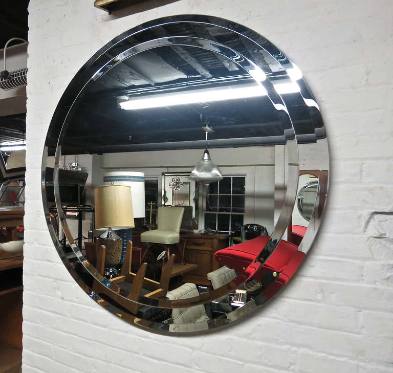 Round beveled edge Mirror with a 3 1/4 inch border of beveled mirrored glass. A  mirror on mirror with the inner measuring 37.75 and the outer 44 1/4. The edges are slightly faded due to age its the kind of wear you would want on a 50+ year old