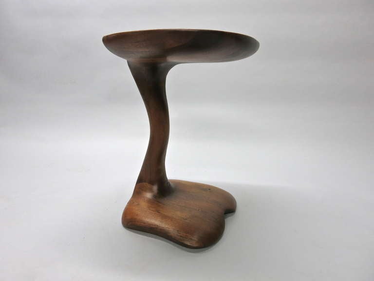 Side Table in free form walnut made in three pieces top and bottom joined by a curved single leg in the center.