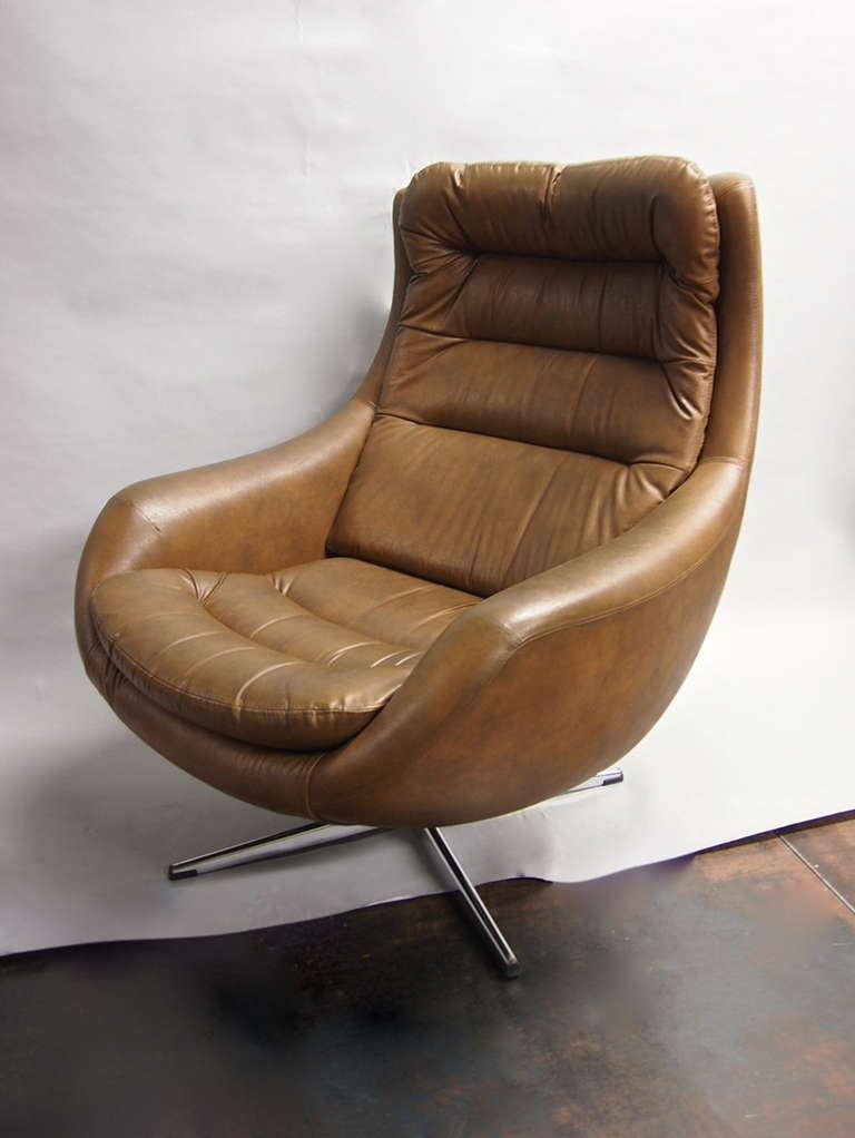 Brown vinyal swivel chair with ottoman both signed Made in Sweden have the same splayed  base