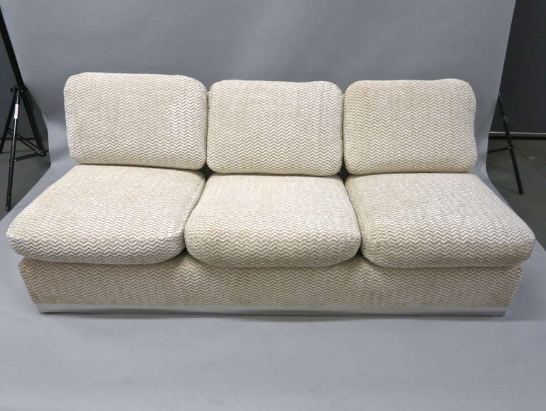 Pair of armless sofas custom made in the 1970's and designed by Valerian Rybar for a New York residential commission. They have been recently upholstered and are fully covered in fabric. Each sofa is supported on a 2