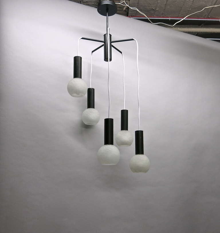 Ceiling fixture with five hanging lights in white crackled glass and enameled black metal hardware. The height of each light can be adjusted and the wire can be changed to black if requested. As shown, the overall is 40 inches.