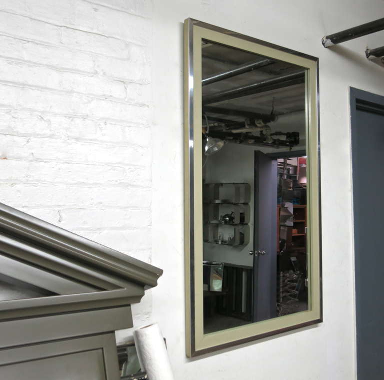 Pair of rectangular wall mirrors framed in enameled wood with a polished metal trim. Both mirrors have the original backing with mounting hardware that is set for horizontal or vertical hanging and original labels that read 
John Widdicomnb Co.    