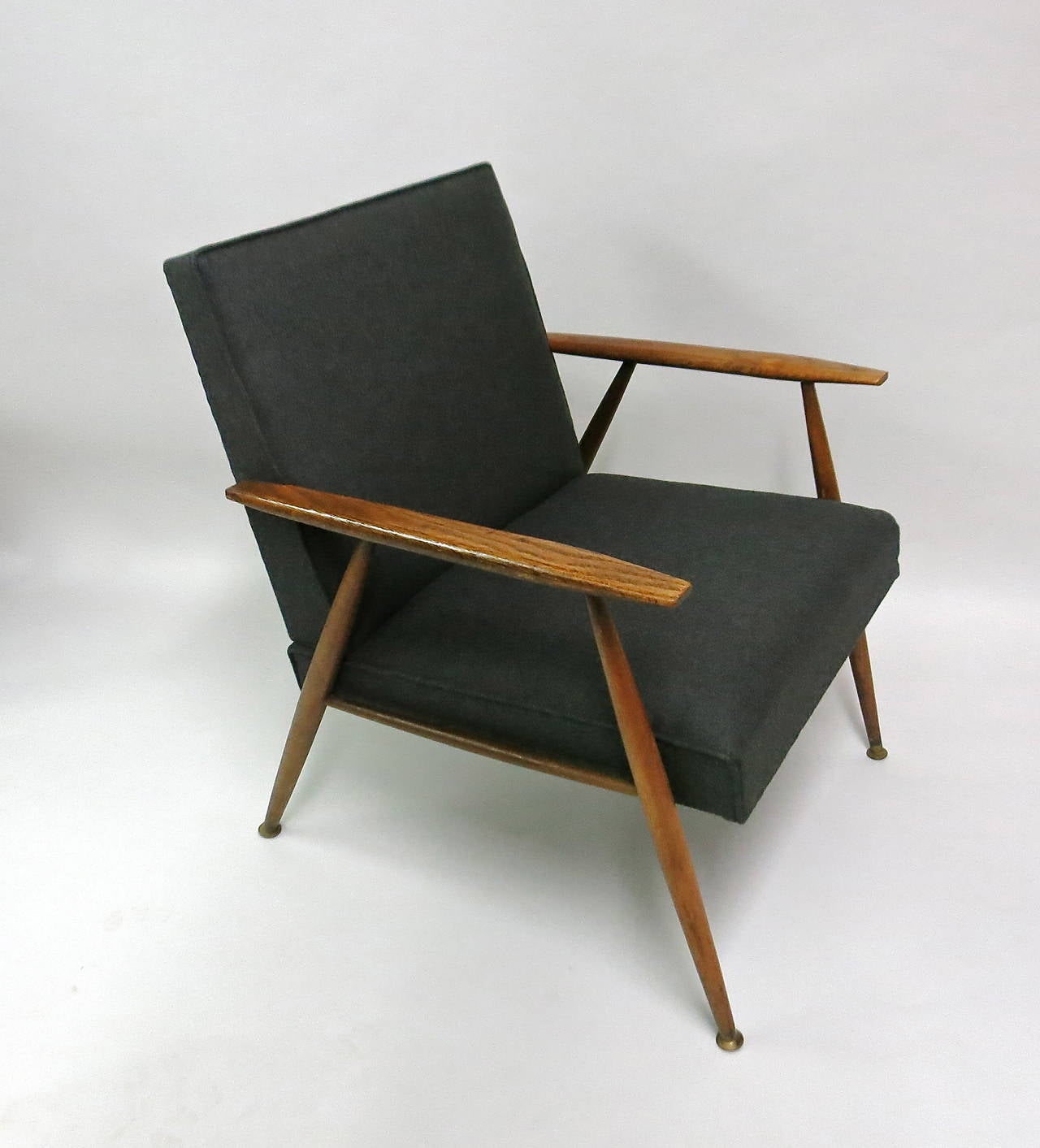 Pair of armchairs have a walnut frame with upholstered seat and back. The cushions are sewn in and recently done in a vintage grey wool fabric.
All four legs are tapered, top and bottom with a brass sabots on each. The sabot connects to an original