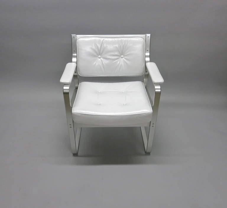 Set of six dining chairs all with arms and upholstered in white leather. The frame is in brushed aluminum all with the original label that reads JOC 
for J.O. Carlsson the manufacturer.