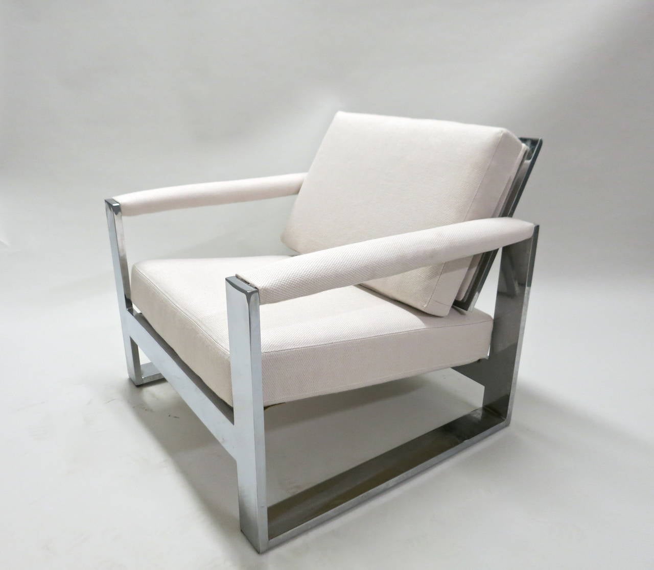 Pair of Milo Baughman designed lounge chairs that have been reupholstered in the off-white fabric shown and made of three inch wide, flat-bar, polished chromed steel frames. These are strong and sturdy produced in the 1970s. 