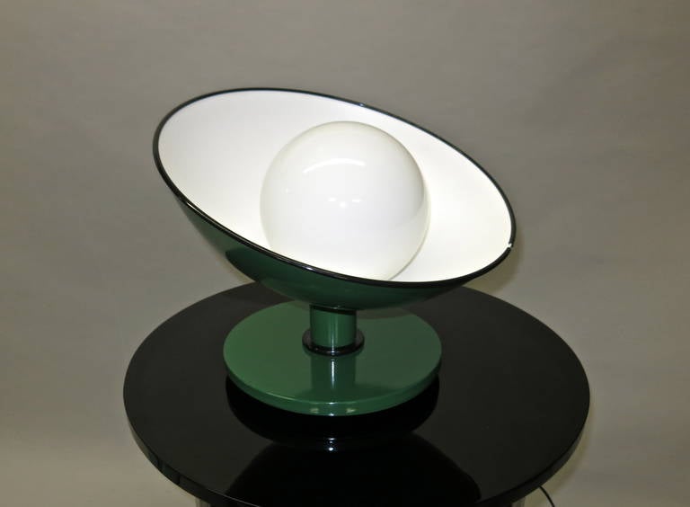 Table lamp has a round base with a short tubular neck that supports a half round dome shaped shade all in enameled metal trimmed with black rubber. The outside is a dark green and the inside a white enamel. The socket and wiring has been changed to