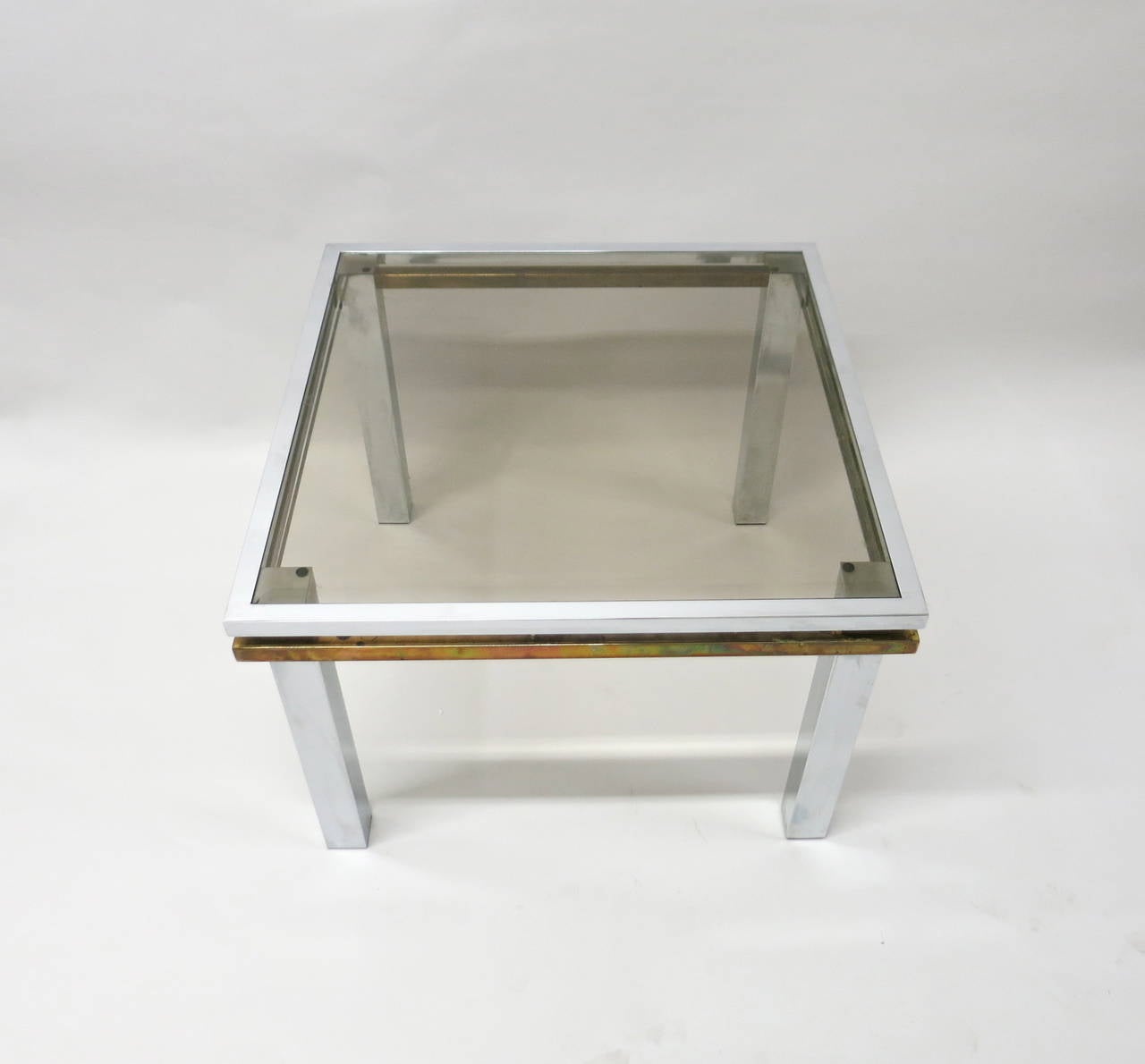 Pair of Side Tables have 2 1/4 inch chrome legs connected by two 1 inch frames, one in chrome and another in patinated brass. Each table has an inset glass top. Legs, frame, glass and tables are square.
