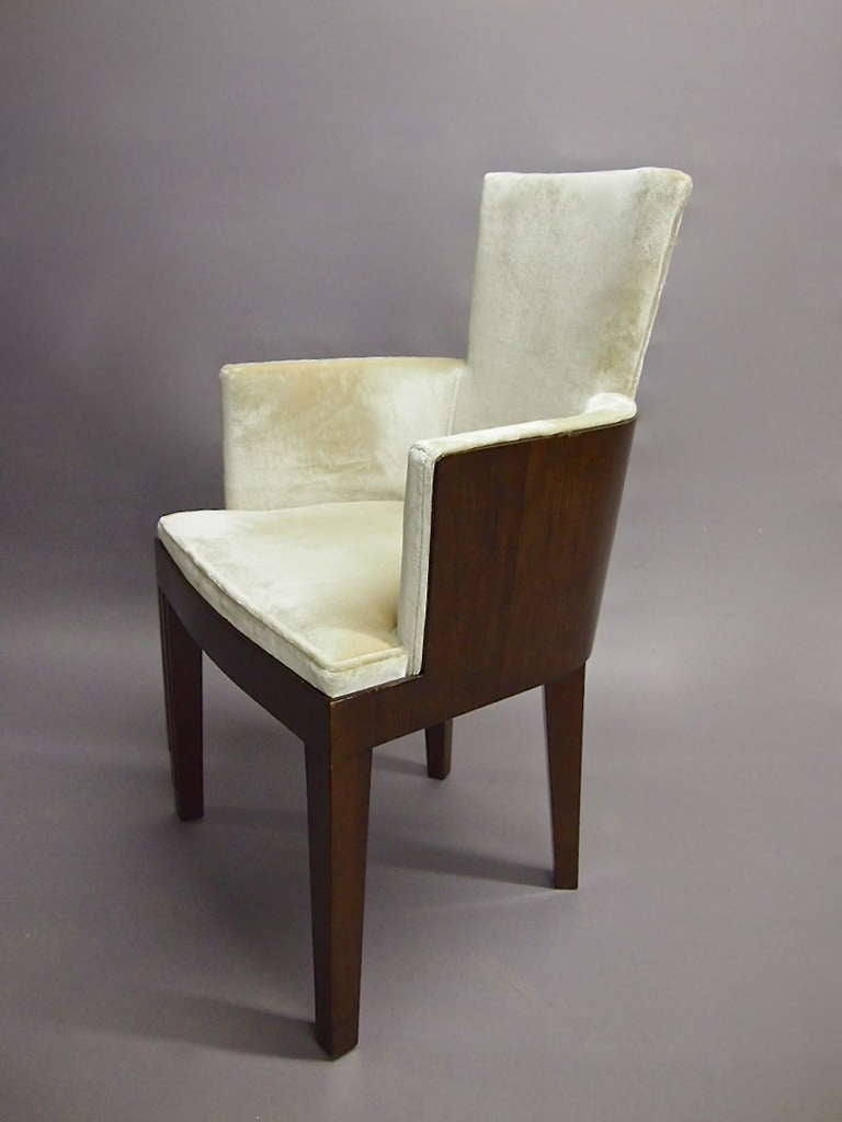 Pair of deco chairs with ebony frame. The seat, back and arms have been recently upholstered in a, vintage, ribbed cream colored, mohair. Both chairs are in excellent condition.