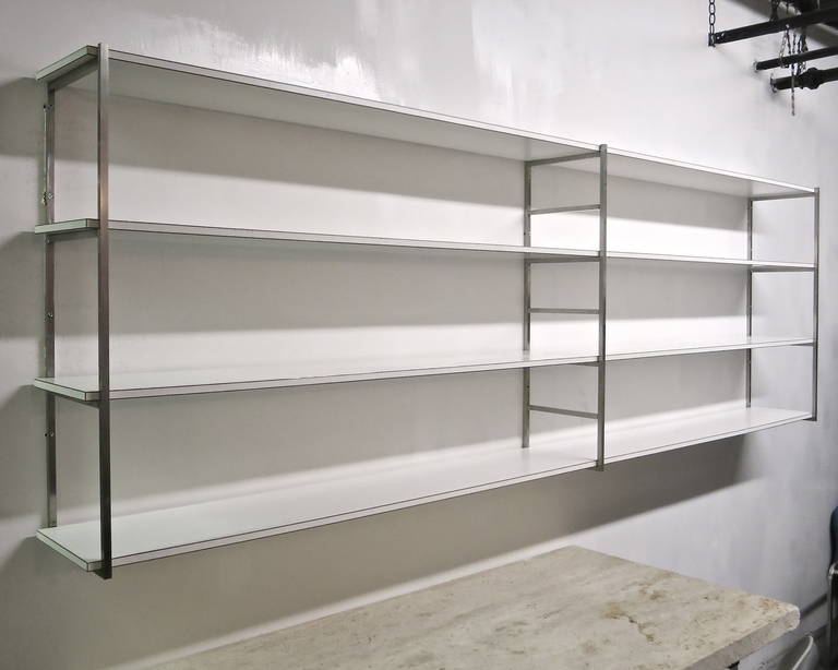 *Winter Sale*
Minimalistic wall-mounted shelving unit comprises four rectangular shelves in off-white laminate that are supported by three solid, brushed steel posts/brackets.