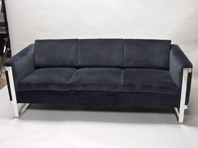 Two vintage sofas upholstered in black cotton velvet. Each sofa is supported by solid polished steel on each side. The metal has been buffed to remove some age related scratches. Both are in excellent condition for vintage furniture.