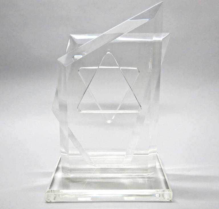 Sculpture signed Van Teal made of solid lucite with two beveled, angular pieces that each have a triangle shape cut in the center and attached to the base. Each angled piece is positioned one behind the other and visually form a star from the front