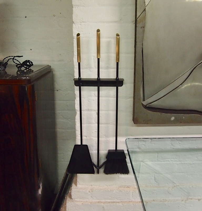 Wall mounted fire tools a shovel poker and broom all with solid brass handles.