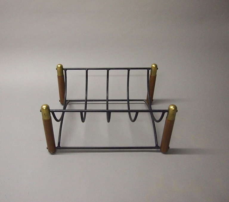 Log Holder for indoor use has four wooden legs that have a decorative patinated brass top at each corner the legs support the arched wrought iron so it cradles the wood and keeps it from the floor