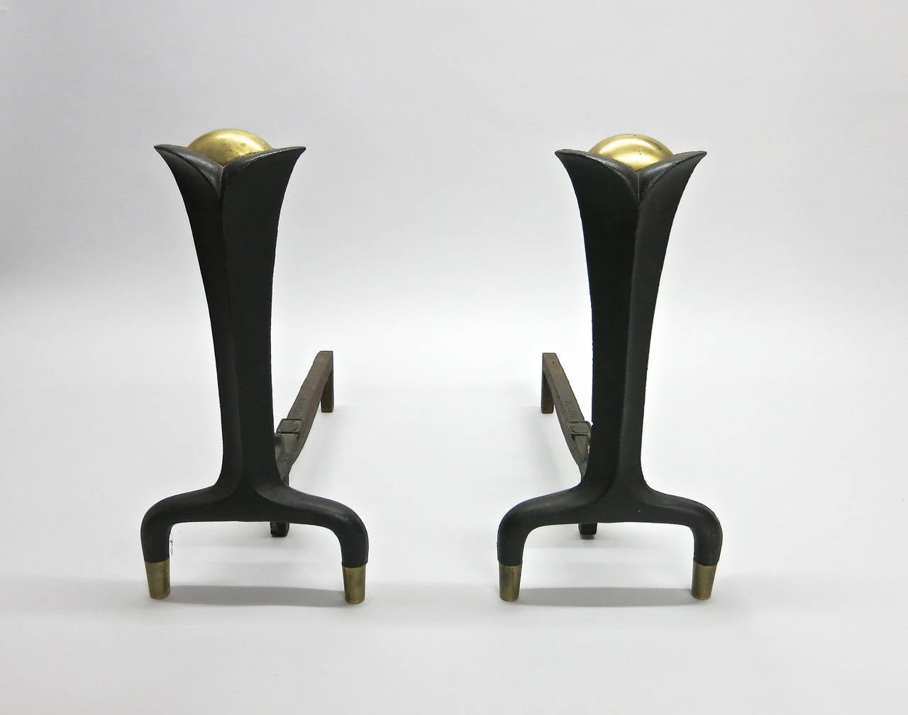 Pair of andirons in cast wrought iron with brass detail designed by Donald Deskey stamped and manufactured by Bennett Co.