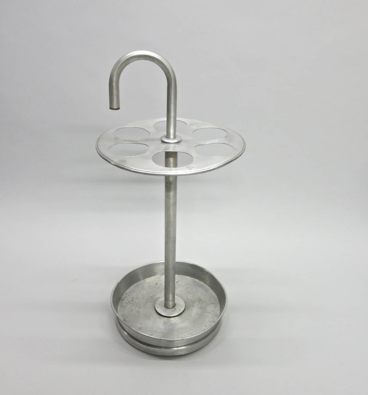 Umbrella Stand in anodized aluminum with a cane handle and a round weighted base able to hold six umbrellas