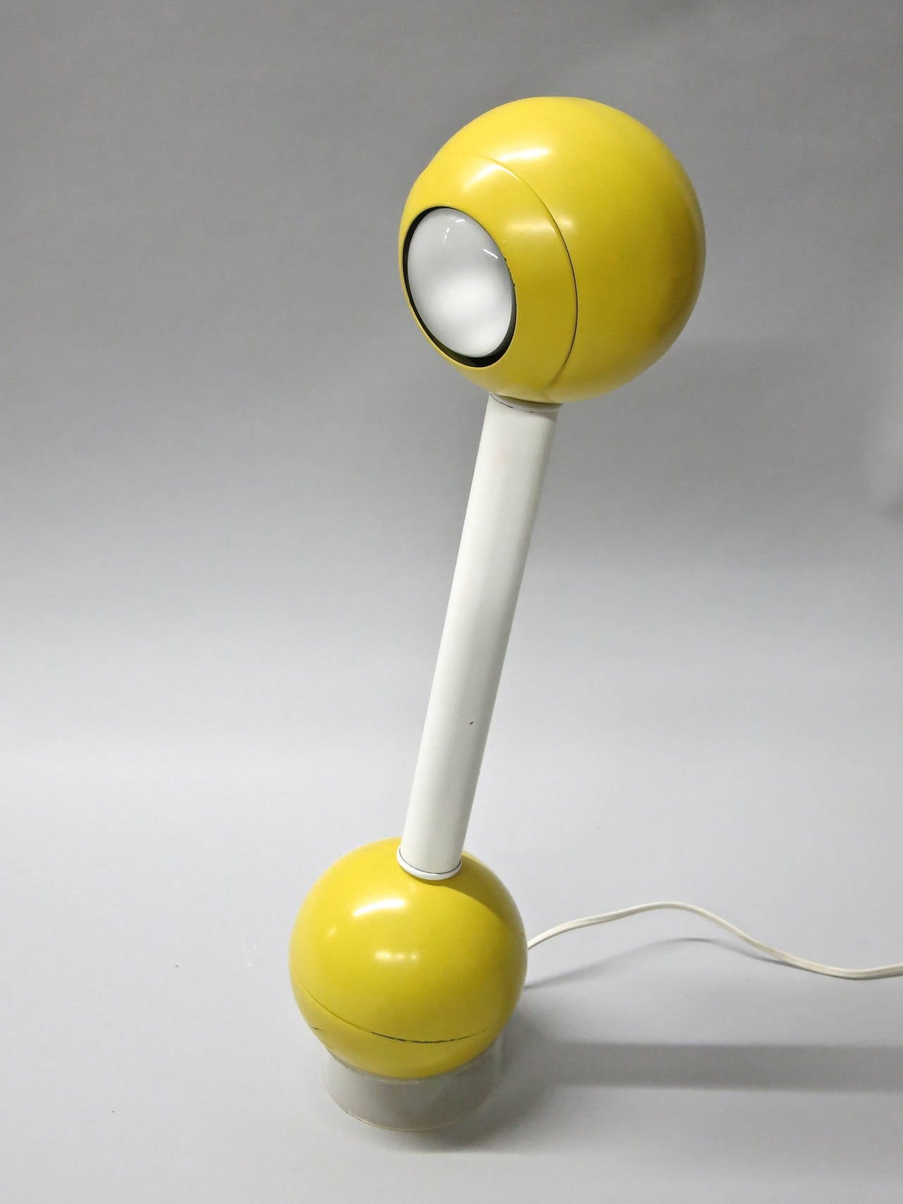 Barbell desk lamp in yellow and white enameled metal that rotates and rests on a lucite base, designed in the 1970s by John Mascheroni for Kovacs
