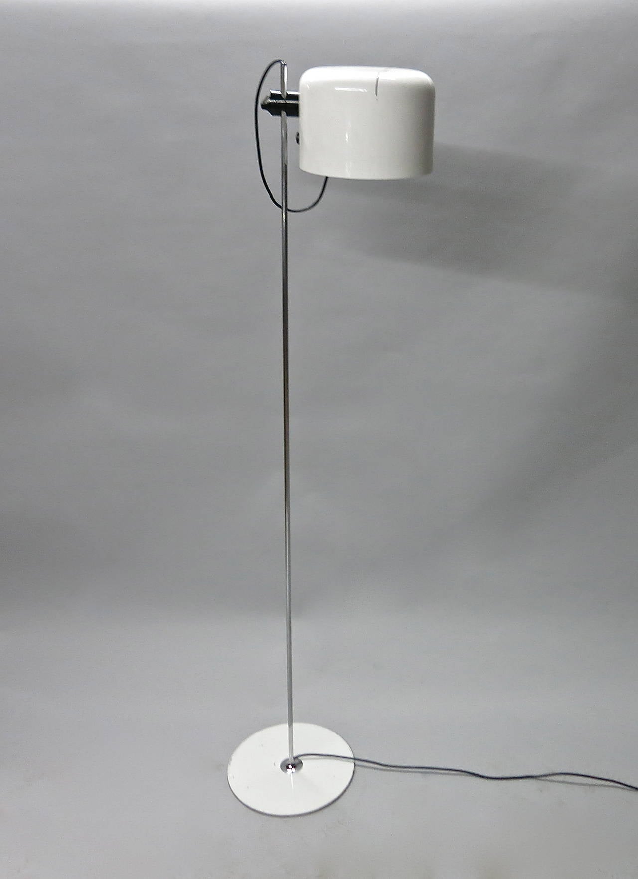 Vintage Coupe Floor Lamp in white enameled steel and chrome. Lamp has an adjustable shade that slides up, down and rotates. The shade is attached to  tubular chrome rod and supported by a round weighted steel base.
Image #6 shows the original