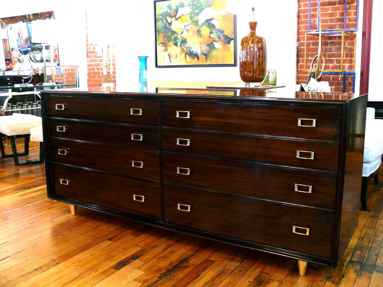 Exceptional eight-drawer dresser by Paul Frankl for John Stuart
Newly refinished in a deep espresso with high grain and polished brass hardware and legs.

--------------
Paul Frankl - 
Arriving in the United States in 1914, Viennese-born Paul