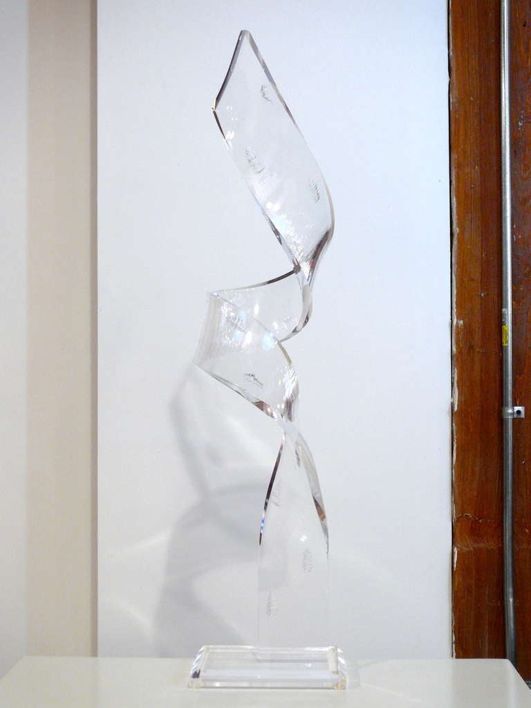 This is a very unusual lucite sculpture.  The ribbon band has engraved shells in it.  Sits on a lucite base.  

Please visit Fairfield County's largest freestanding destination for Mid-Century Modern furniture, lighting, decorative art and fine