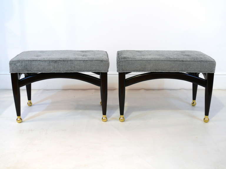 Pair of sculptural benches with solid brass sabots.  Finished in a deep espresso with new grey chenille upholstery with  4 buttons on top.