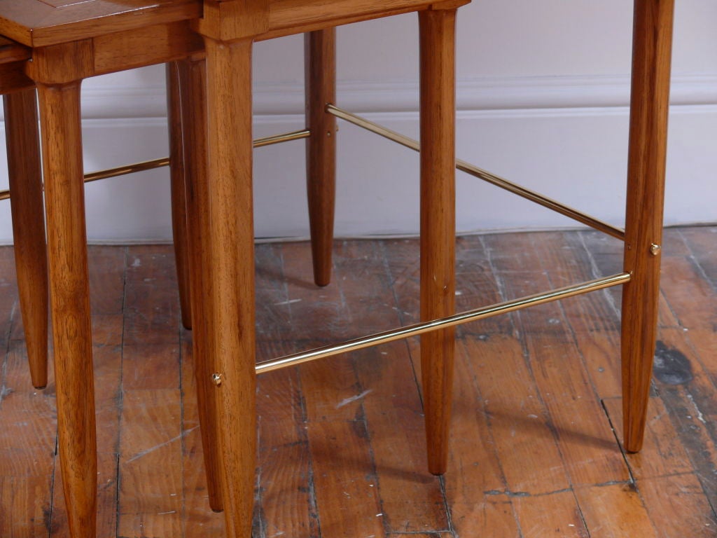 Oak nesting tables with brass stretchers in a polished finish in the style of Paul McCobb. Refinished and ready to use.

 