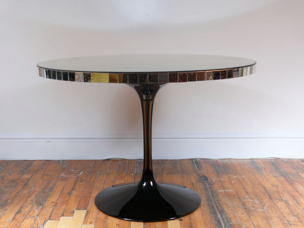 A seamless blend of modern form and 21st century reimagination is evidenced in this one of a kind table.  A mercury mirrored top with a baguette edge rests upon a 1960's tulip base, newly coated with a black metallic car finish.

Please visit