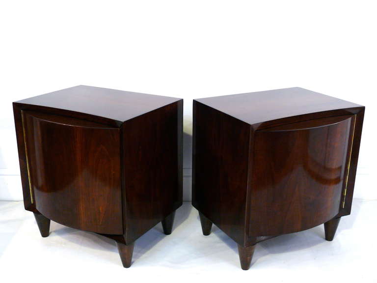Pair of bow-front end tables by Modernage. Incredible attention to detail is found on the rounded front piano hinged doors, the conical legs.