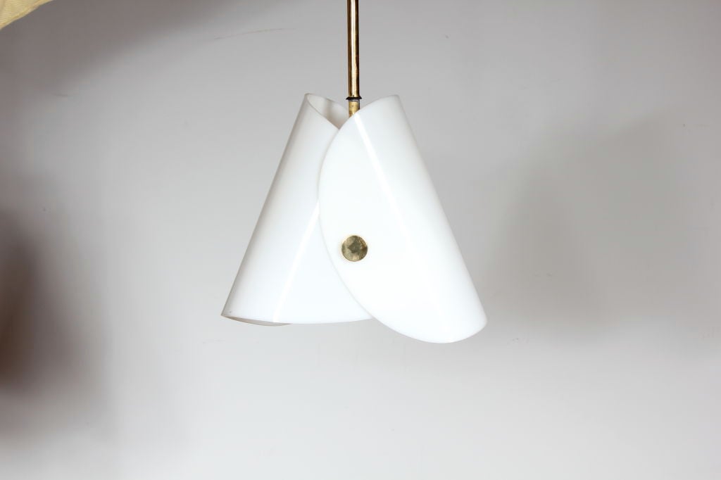 This is a very unusual pendant lamp made of a very thick white resin. It is wrapped on both sides and held together with a brass disc both front and back. Inside is a socket which holds a standard bulb. The light can be adjusted to any length with