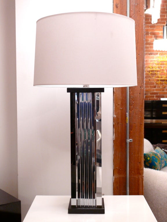 Tall pair of chrome skyscraper table lamps on black bases. The sides of the lamps appear to be pleated in a zig zag pattern giving them an Art Deco feel. New wiring and nickel sockets. Shades not included.
