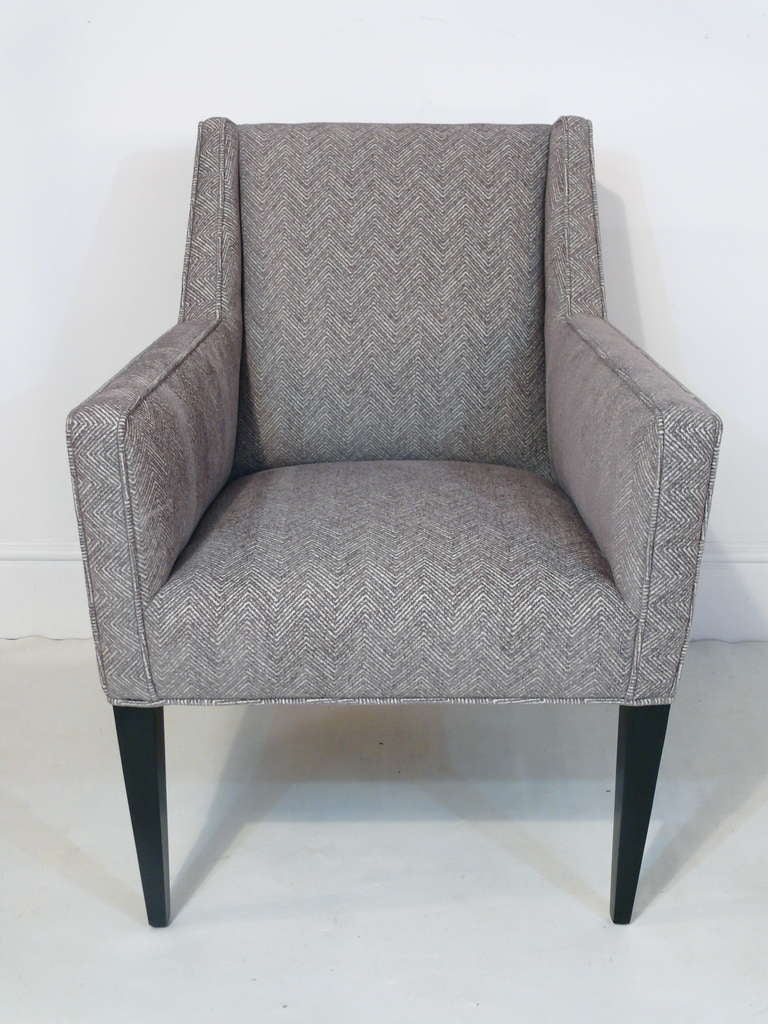 Elegant chair by Edward Wormley for Dunbar. Classic Mid-Century lines are enhanced by a grey chenille herringbone fabric. Legs newly refinished in black and newly upholstered.

 