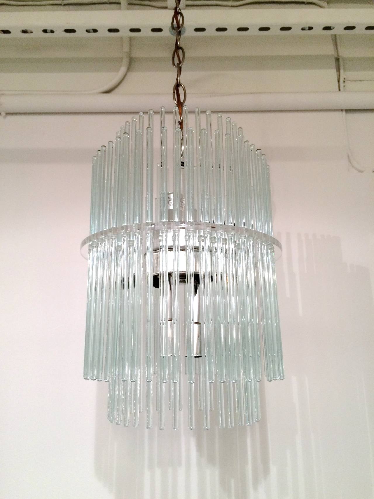 Gorgeous two-tier Lucite chandelier by Gaetano Sciolari for Lightolier with chrome sockets and hanging glass rods. The chandelier takes eight 40W candelabra bulbs. Fully rewired.