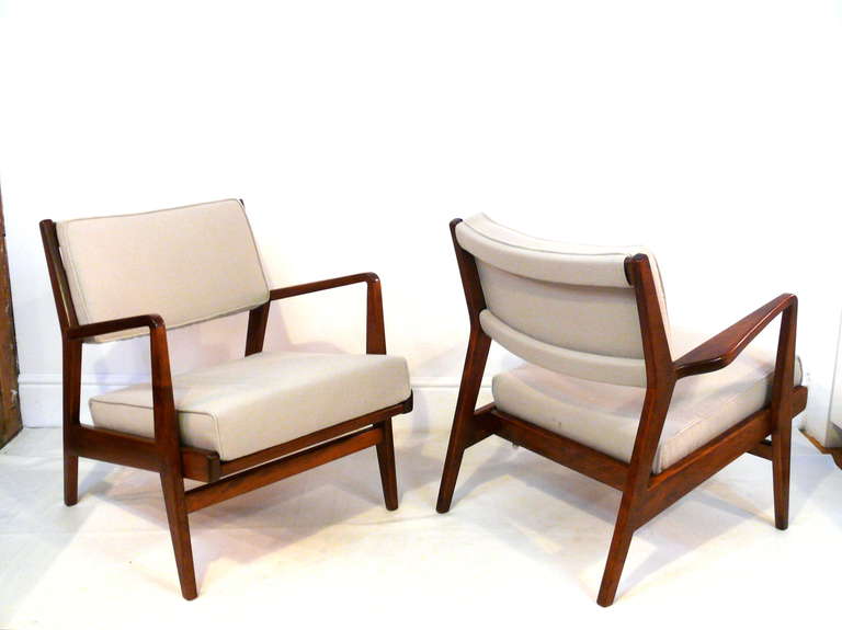 Beautiful pair of armchairs by Jens Risom.  The sculpted frame has been refinished in a satin natural walnut with accentuated grain.  The removable cushions reupholstered in a sage colored felt.