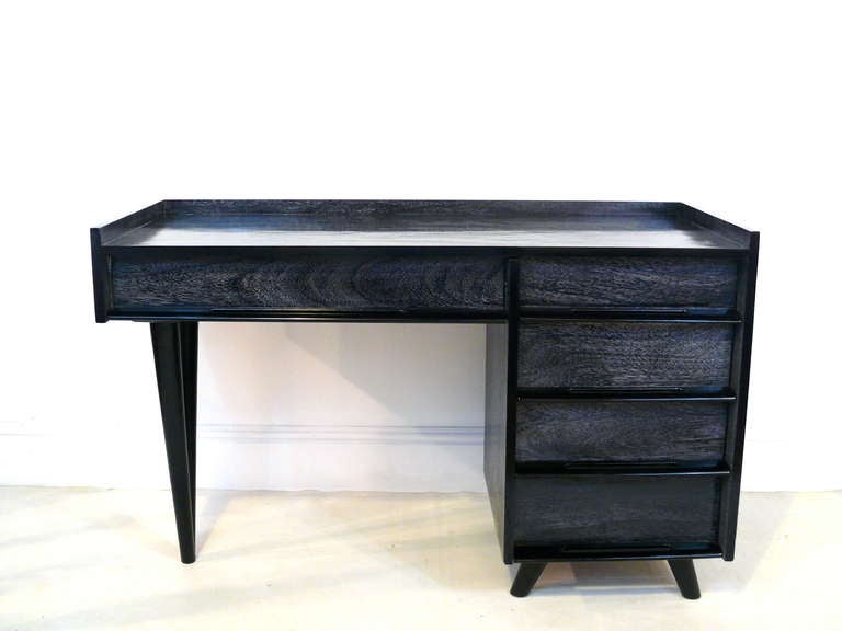 Asymmetric five-drawer desk by Edmond Spence.  Newly finished in a black ceruse with solid black handles.  Top has a wooden gallery around the perimeter.