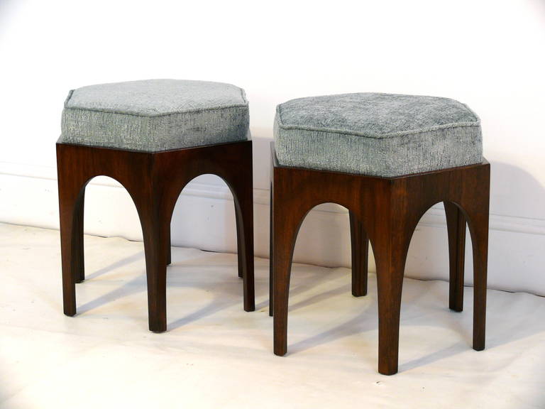 Pair of sculptural hexagonal shaped ottomans with ached detail reminiscent of the work of T.H. Robsjohn-Gibbings. Each ottoman has been carefully refinished in a medium walnut with exposed visible grain and upholstered in a soft chenille/velvet.