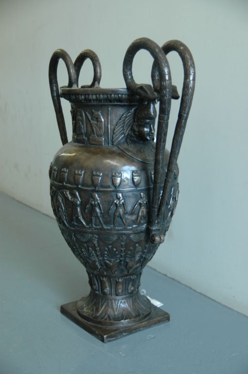 Une paire de très grandes urnes fortement moulées en bronze patiné dans le goût néo-égyptien avec des sculptures profondes.