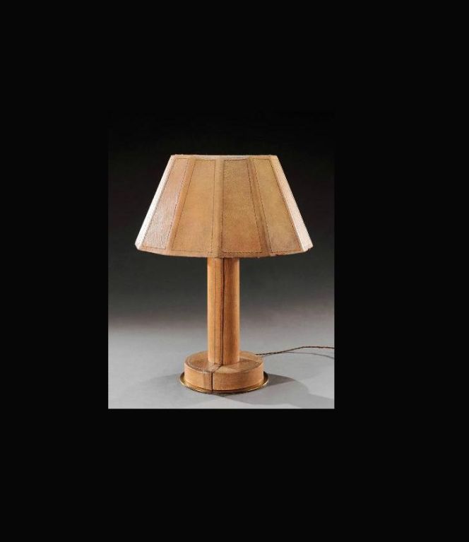 Attributed or in the manner of Paul-Dupre Lafon (1900-1971) desk lamp covered in beige leather and surmounted by a polygonal shade also in leather with stitched details. The quartered cylindrical shaft resting on a circular plinth above a gilt