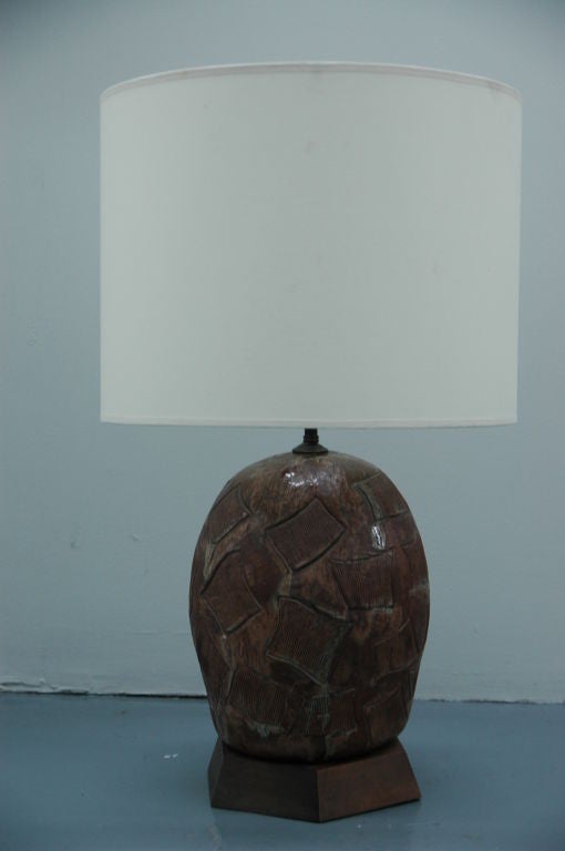 Midcentury table lamp with studio ceramic base. Textured surface of brown and green-grey colors and incised surface designs.

 Mounted on a hexagonal finished wood base, wiring is American / United States outlets.

 