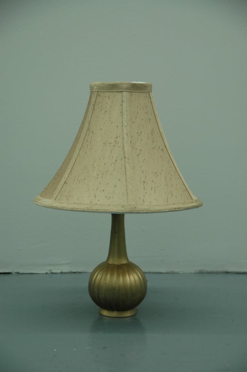 A pair of small bedside or dressing table lamps, the bases in gilt metal. Designed by Danish metalsmith extraordinaire Just Andsersen. Andersen, an innovator in his time, developed the metal alloy 'Disko Metal' used in many of his