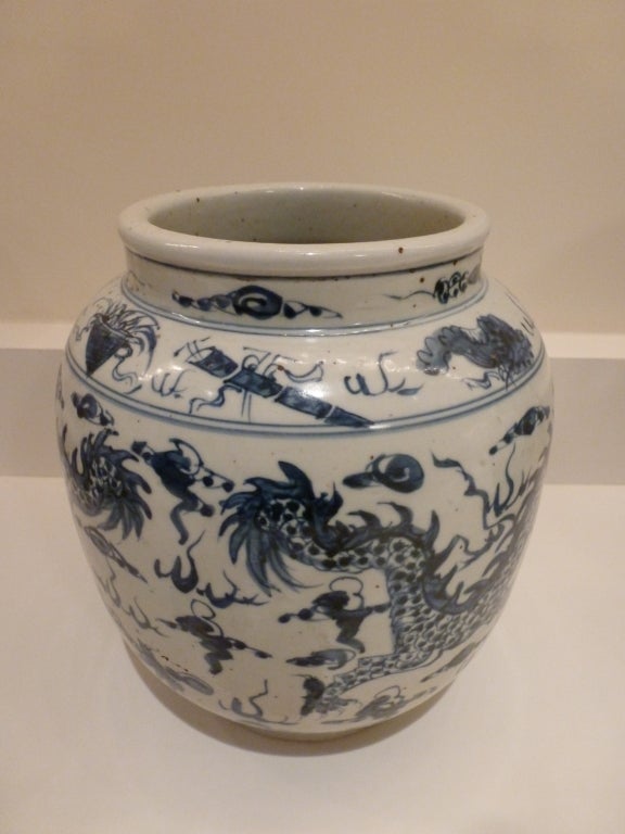 A blue and white wide mouthed jar with depictions of dragons.