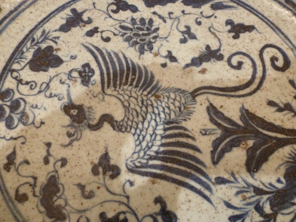 A blue and white ceramic bowl, the basin with central depiction of a Phoenix surrounded by scrolling foliate designs.