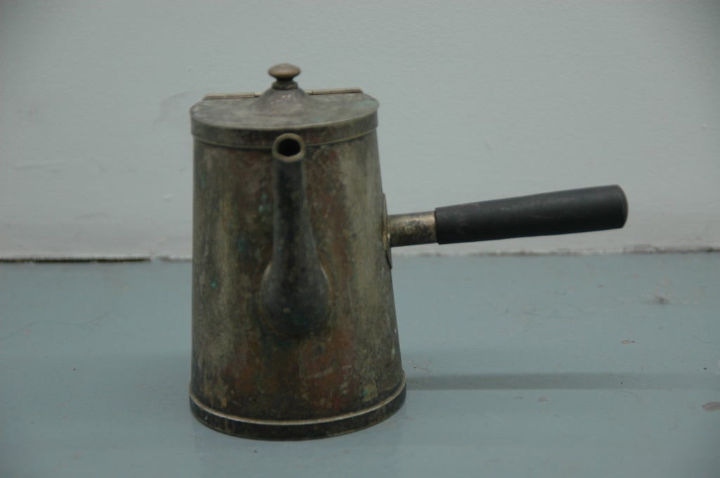 A straight handled tea kettle with good tarnish to the silver with a mahogany handle.