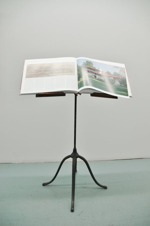 Elegant, adjustable music stand made of oak and cast iron, late 19th century and likely British.

Shown in second image with large folio of Frank Lloyd Wright's early designs.