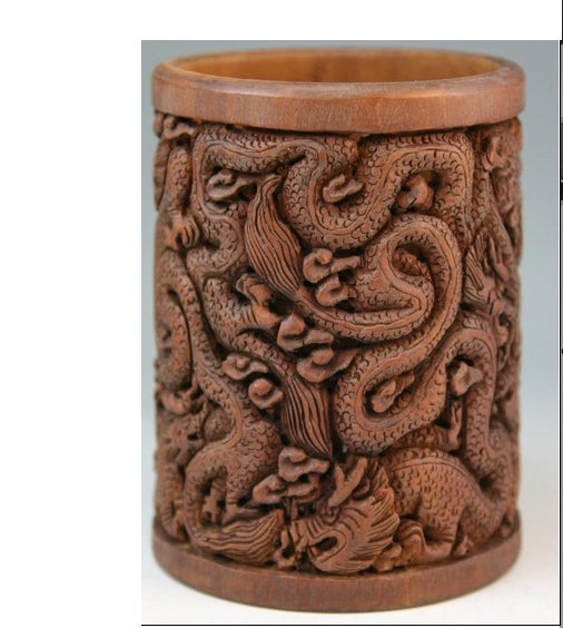 An intricately Chinese carved wood brush-pot: Round form, with deeply cut design of twisting dragons in flight in cloud scrolls on the body.