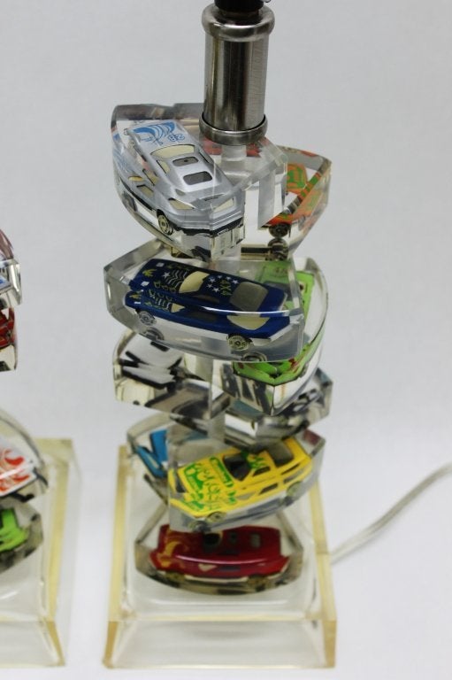 Awesome pair of table lamps, each with a spiral column of lucite sections containing Matchbox / Hot Wheels toy cars. 

Recently rewired, US wiring. 

Dimensions listed are for the lamp bases without a harp/shade
