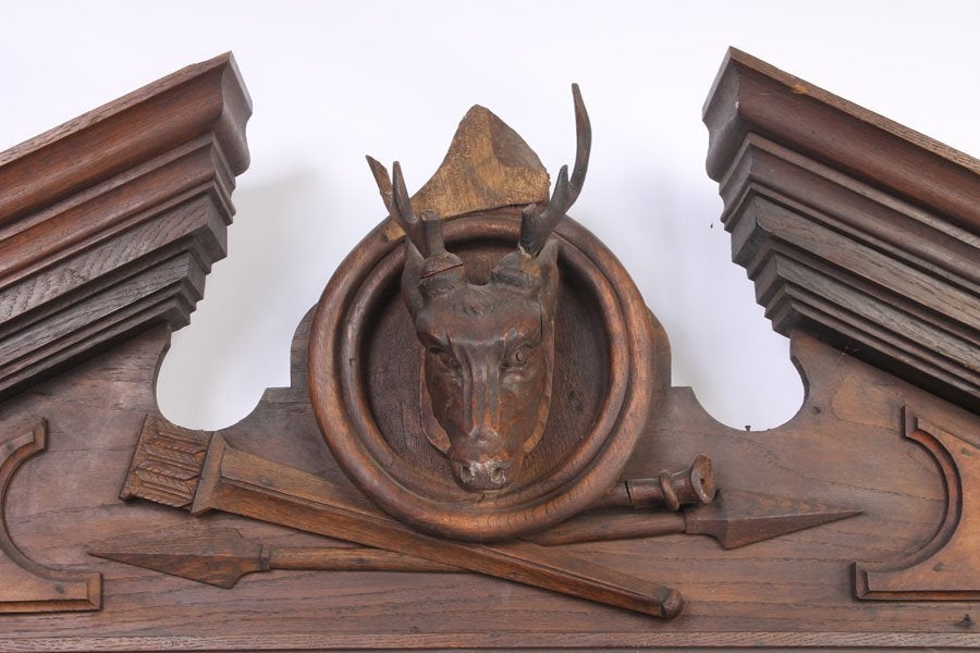 Forcefully carved overmantel mirror in walnut. The Renaissance Revival design capped by a broken architectural pediment centered around the stag head, all above the large (and probably original) mirror plate. Various motifs and border designs