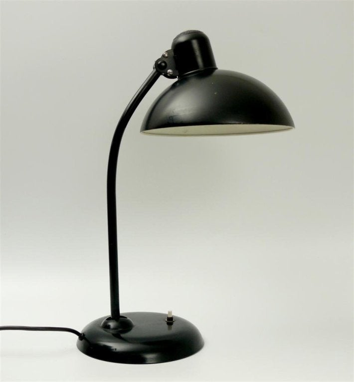 Black Bauhaus desk lamp designed by Christian Dell in 1933 and produced by Kaiser for a number of years. Relatively old example of the model.

Sleek modern design, currently being sent for re-wiring in US.

Height varies based on position.